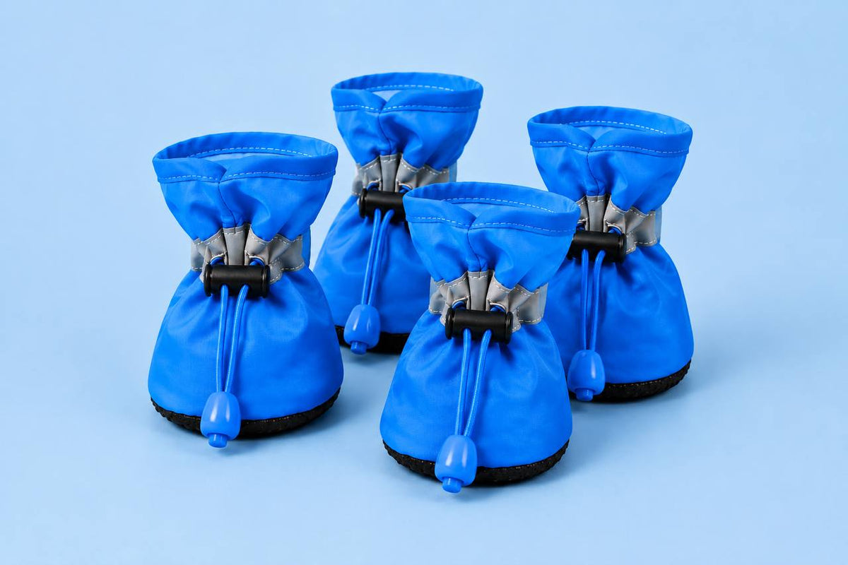 Set of four blue Pawro anti-slip dog boots with drawstring toggles and black rubber soles, on a blue background